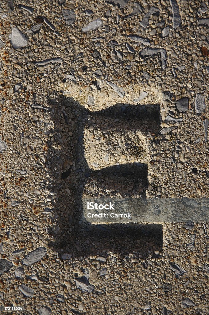 The Letter E This is the letter E. It was stamped into the top of a concrete highway divider. Alphabet Stock Photo