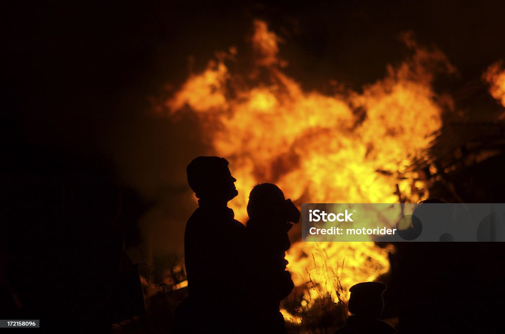 Padre carying bambino con fuoco sfondo. - Foto stock royalty-free di Falò