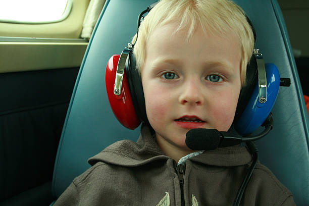 Cтоковое фото Ребенка носить наушники в самолета
