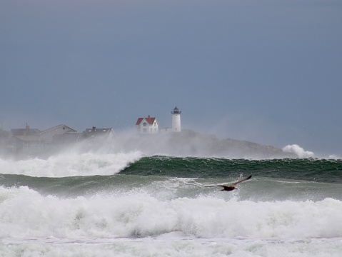 Nubble lighthouse behind stormy seas in York, Maine