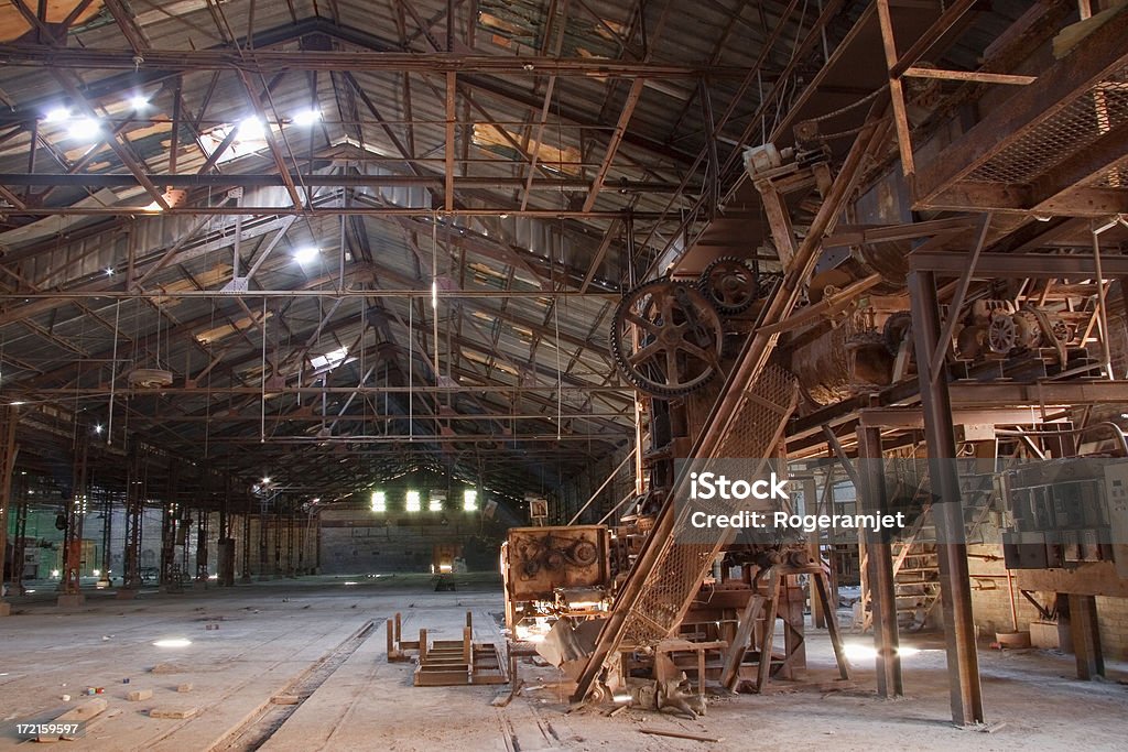 Dead Technology/ghost factory Holes in the ceiling of a 19th century brick making factory illuminate a rusting brick machine. Abandoned Stock Photo