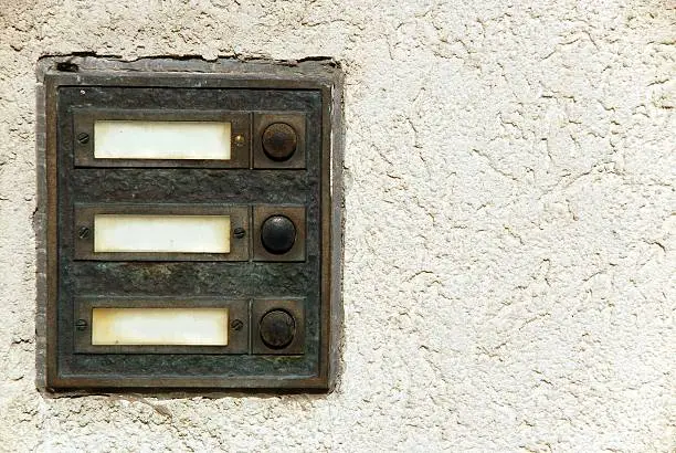 Panel of three old door bell buttons