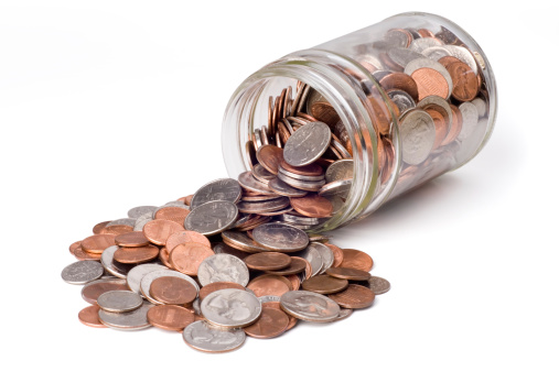 Coins spilling from a jar bank.  Isolated on white with clipping path.