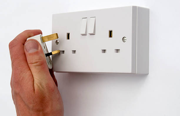 Plugging In British Plug and Socket stock photo