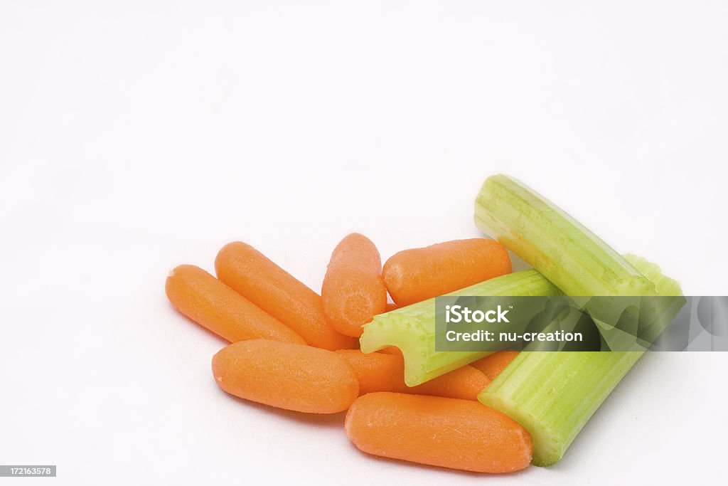 Baby carrots and chopped celery on white background Pile of carrots and celery on white. Beauty Stock Photo