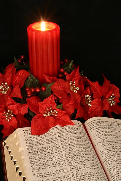 Religious: red Christmas Candle & open Bible with poinsettias stock photo