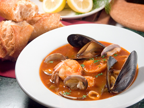 Robust stew, similar to a bouillabaisse, features a variety of the sea's edible treasures such as baby manila clams, mussels, prawns, calamari, sea bass, and crab in a rich tomato base.