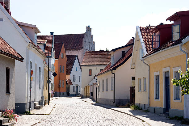 Empty street with several buildings "A quiet street scene in the medieval town of Visby, Gotland, Sweden." gotland stock pictures, royalty-free photos & images