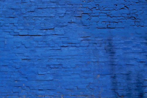 Photograph of a brick wall painted blue.