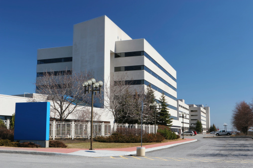 Empty hospital main building facade view from inner garden - Covid-19 Concepts