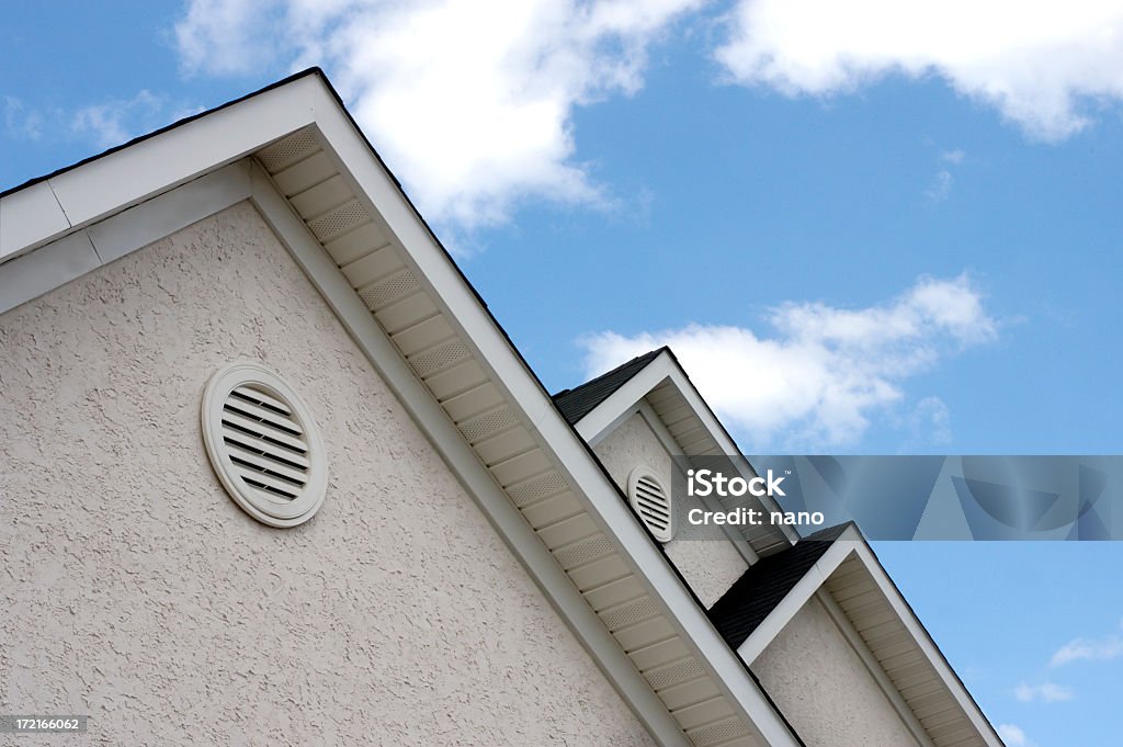 Close up of roof peaks against blue sky adjacent peaks on a house Air Duct Stock Photo
