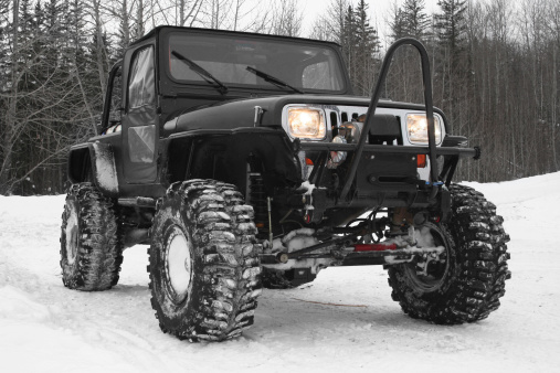 Black 4x4 Jeep with agressive tires and winch - built for offorading. Parked at the entrance to a trail in winter time in Northern AlbertaRelated Images: