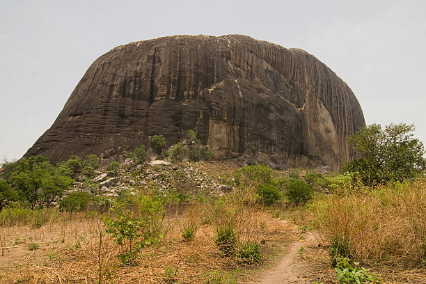 The way to Zuma Rock "Zuma Rock, a large monolith in Niger state close to Abuja. A face can be seen eroded in the rock at about a quarter of the rock from the right." abuja stock pictures, royalty-free photos & images