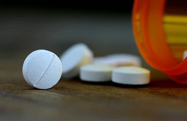 Aspirin Pills spilling out of a pill bottle. aspirin photos stock pictures, royalty-free photos & images