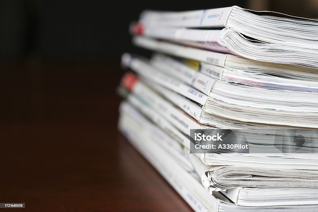 Stack of magazines over a wooden desk Large stack of magazines - shallow depth of field. Magazine - Publication Stock Photo