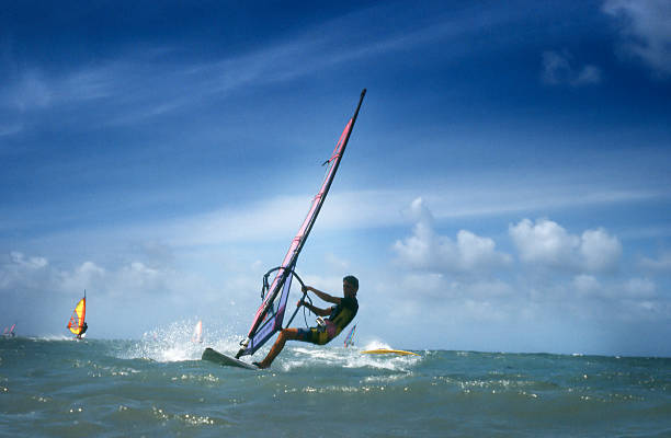 Surfers Windsurfers at the shores of Maui. Scan of a colour slide. Film grain visible at full size. windsurfing stock pictures, royalty-free photos & images