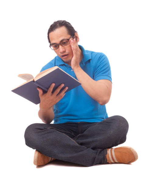 istock Young Man Sitting on Floor and Reading a Book, Shocked Gesture 1721693964