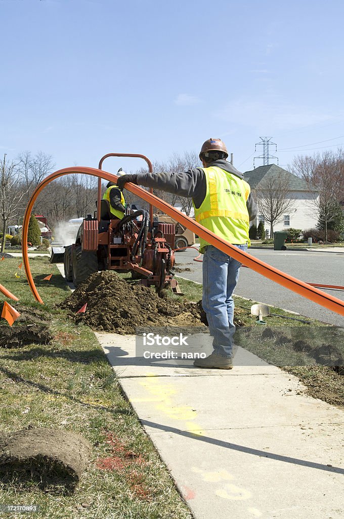 Fishing the Cable Two installers work together to install conduit for fiber optic cable. Fiber Optic Stock Photo
