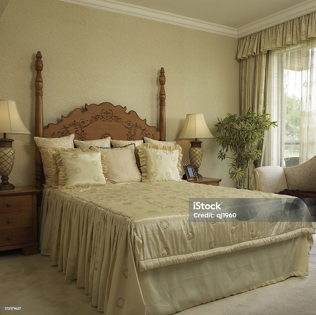 Luxury master bedroom "Classical style bedroom with arm chair, the wooden headboardand with bright fall to the ground windows,beijing,china." Armchair Stock Photo