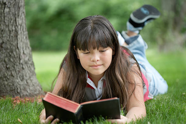 ragazza di lettura della bibbia - outdoors looking at camera little girls child foto e immagini stock