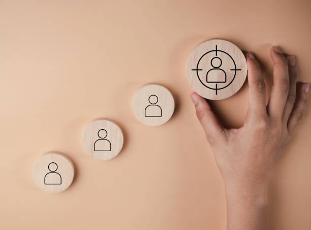 HRM or Human Resource Management, Target customer concept. Among staff icons for human development recruitment leadership on Wooden label. Personalization marketing, customer centric strategies. gestión de recursos humanos o gestión de recursos humanos, concepto de cliente objetivo. entre los íconos del personal para el liderazgo de reclutamiento de desarrollo humano en la etiqueta de madera. marketing de personalización, estrategias centradas