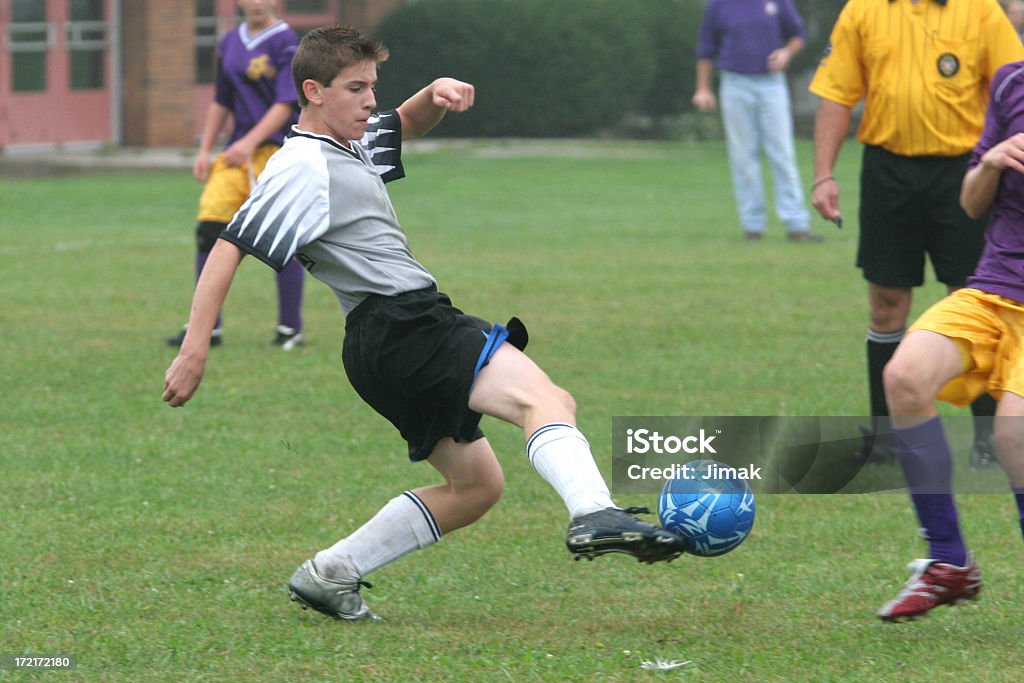 Austin Soccer 3 Young teen male soccer player with kick on the ball.  Side view.  Full form. Adolescence Stock Photo