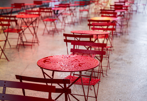 Rain-soaked red tables and chairs under rain in Times Square, New York City, USA