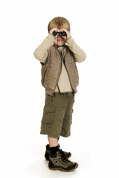 4 year old boy looking through his binocular.
