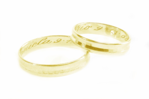 Two golden wedding rings with inscription inside in soft focus