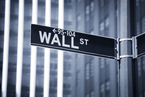 Wall St. street sign with tall buildings in the background