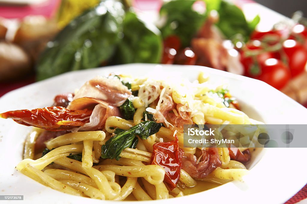 pasta con tomate y queso parmesano con jamón, espinacas - Foto de stock de Alimento libre de derechos