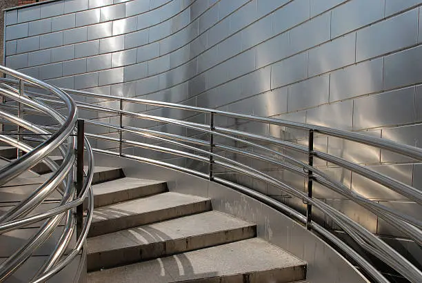 "Looking up a staircase with stainless steel, cladding and railings"