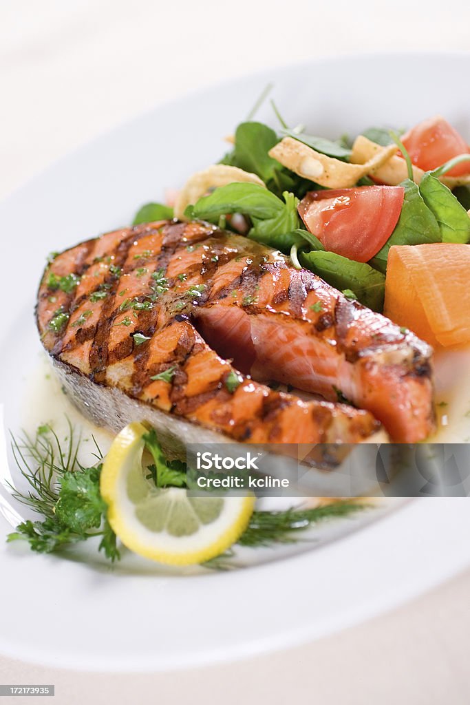 Grilled Salmon Entree Succulent grilled salmon steak with a fresh crisp side salad.  Shallow dof Barbecue - Meal Stock Photo