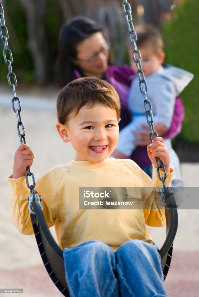 Little Boy en un patio de juegos Swing - Foto de stock de Actividades recreativas libre de derechos