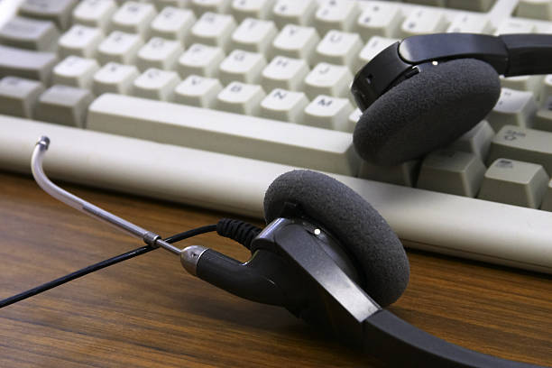 A headset resting on a desktop keyboard stock photo