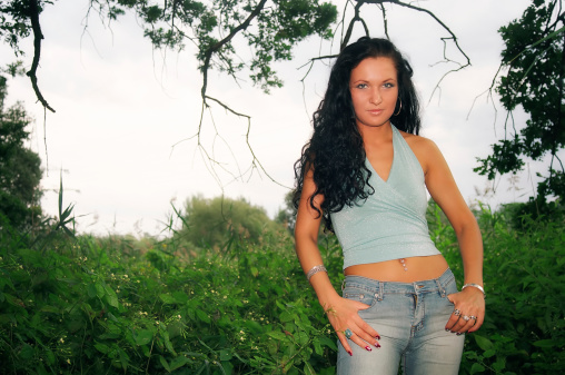 Woman standing outdoors on the edge of the forest