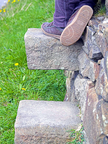 istock Young person's feet pausing on a stile in stone wall. 172174249