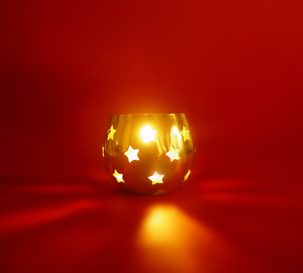 a glowing candle holder on a red background