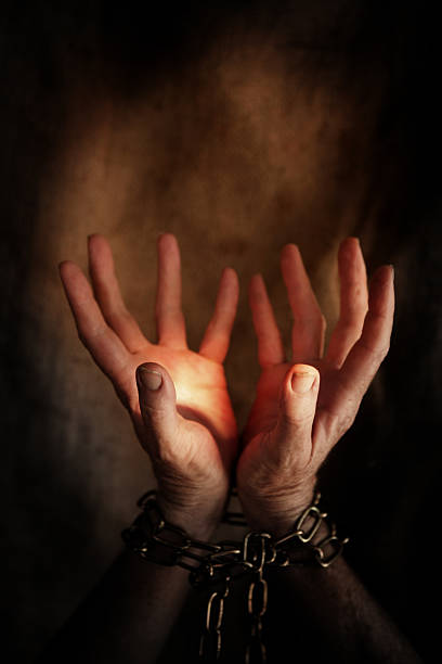 istock Two chained hand illuminated in darkness by a ray of light 172175129