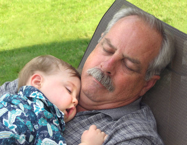 Nap in the Shade Grandfather and grandson enjoying a summer day's nap in the shade. sleeping grandpa stock pictures, royalty-free photos & images
