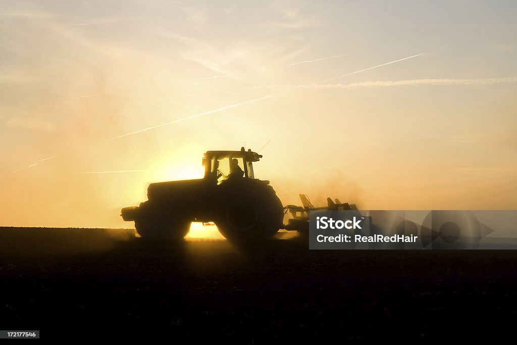 Tracteur ploughing au coucher du soleil - Photo de Agriculture libre de droits