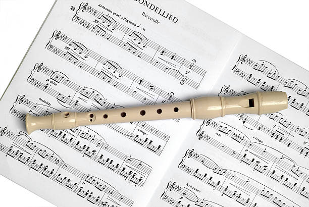 Recorder and sheet music on white stock photo