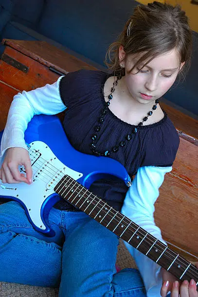 Photo of Young Teen Playing Electric Guitar