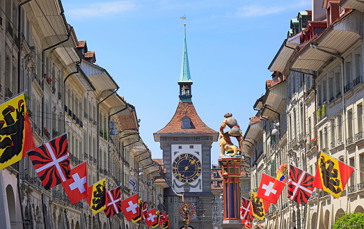 Street view on Kramgasse with fountain and Zytglogge Clock Tower\nin the old town of Bern city. It is a popular shopping street and medieval city centre of Bern, Switzerland