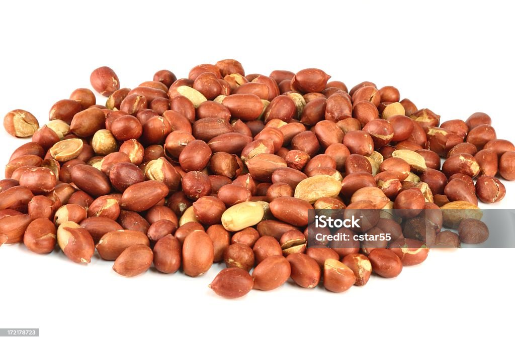 Spanish Peanuts in pile on white Spanish or red skinned roasted peanuts Peanut - Food Stock Photo