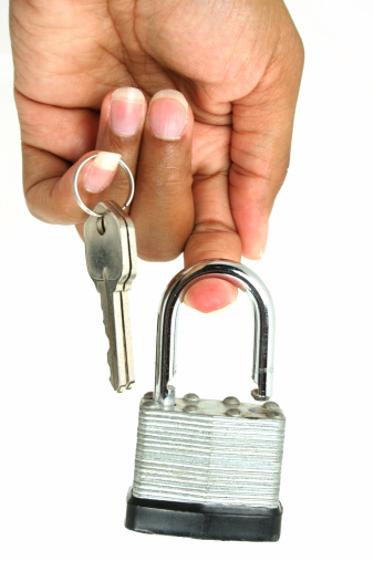 Lock and key dangling from ethnic fingers