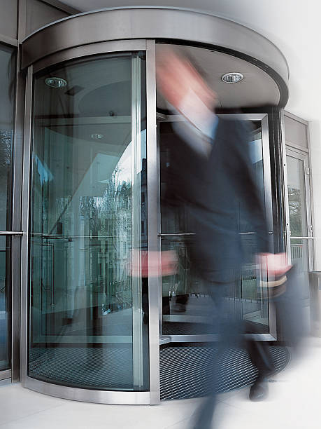 istock Motion-blurred businessman exiting building's rotating doors 172178947
