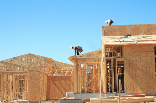 New houses being framed by two construction workers. Canon 30D, 28-55mm lens.