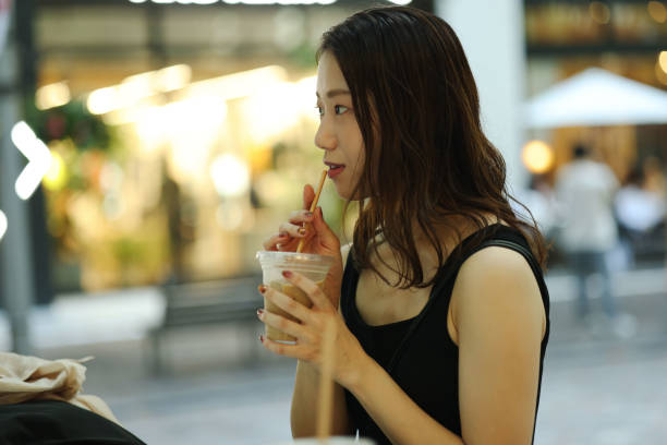 istock Young beautiful woman dinking coffee at shoping street 1721798369