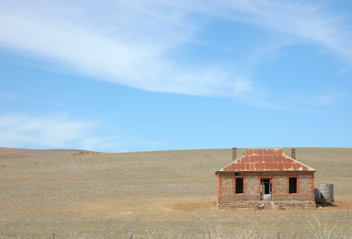 Abandoned farmhouse in field.